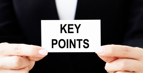 A man holds a business card with the written word KEY POINTS