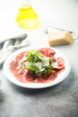Traditional beef carpaccio with parmesan cheese and arugula