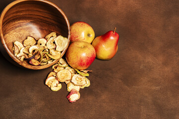 Fototapeta na wymiar Dried apples and pears on a brown background
