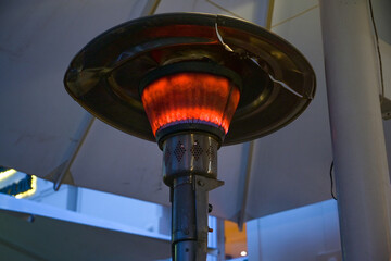 Gas burning patio heater on a restaurant terrace has dire environmental effects, but allows eating...