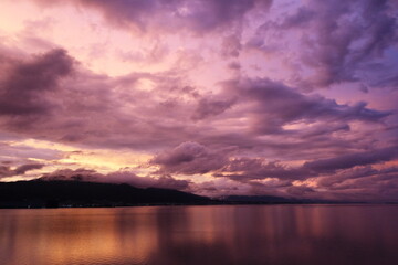 紫に染まった雲とオレンジを反射した水面３
