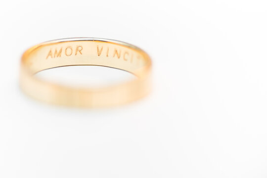 Golden wedding ring isolated on white background - amor vincit omnia engraved