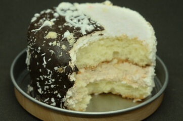 A bitten-off cake on a metal stand .
