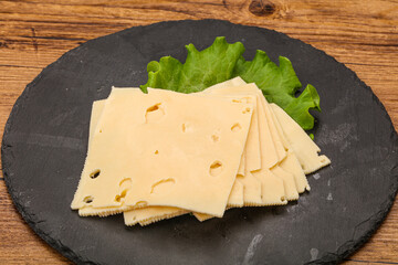 Sliced yellow cheese over board