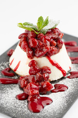 Detail of panna cotta with berry sauce and sugar