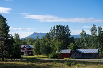 Swedish farmhouses in the countryside on a summers day with a mountain in the background