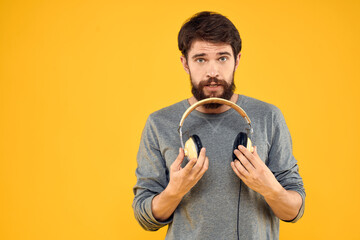 Man in headphones listens to music technology lifestyle fun people yellow background