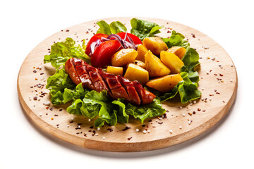 Grilled sausages and vegetables on white background
