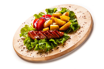 Grilled sausages and vegetables on white background
