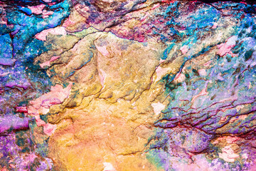 Fototapeta na wymiar Multicolored rock wall from bottom sediments red orange dark rays crack smooth
