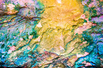 Multicolored rock wall from bottom sediments red orange dark rays crack smooth