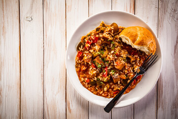 Roast pork meat with rice and vegetables on wooden background