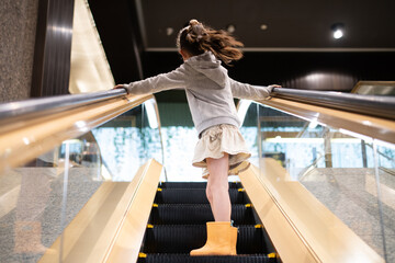 マスクを着用してエスカレーターに乗る少女