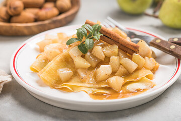 Thin pancakes (crepes) with apple filling, stuffed rolls, Russian traditional food for maslenitsa, French dessert, breakfast with tulips on mother's day