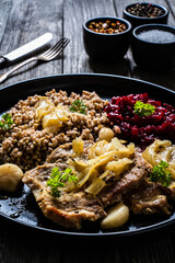 Roasted meat, buckwheat and beetroots on wooden table