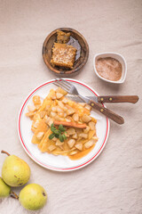 Thin pancakes (crepes) with apple filling, stuffed rolls, Russian traditional food for maslenitsa, French dessert, breakfast with tulips on mother's day