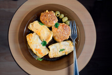 Cabbage rolls with beef, rice and vegetables on the plate. Stuffed cabbage leaves with meat. Dark wooden table and glass plate

