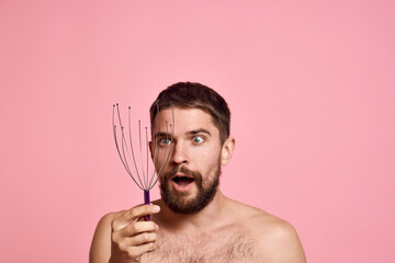 Obraz premium man with head massager relax body care pink background