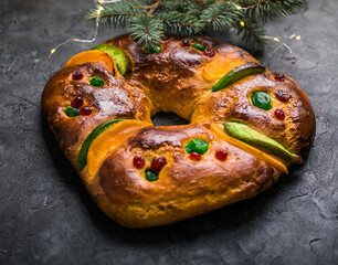 Rosca de reyes, spanish three kings cake eaten on epiphany day, on a gray rustic table