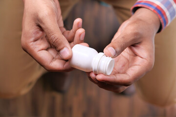 Close up of person hand holding pill container 