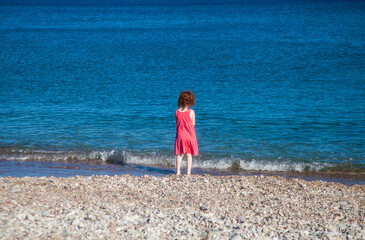 Little girl looking at waves