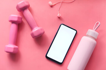 Smart phone with sports equipment on wooden floor.