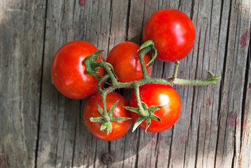 branch of cherry tomatoes on old wood background