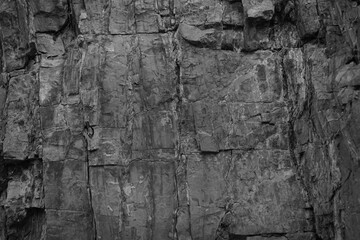 Dark grunge background. Black rock texture. Monochrome stone backdrop. Rough mountain surface....