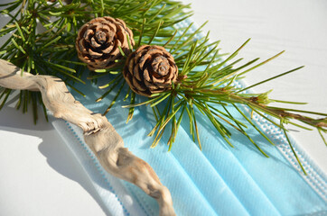 Pine branch with cones on the background of a protective mask.