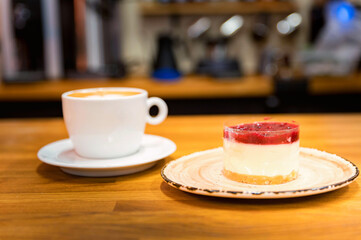Vanilla cake with cup of coffee on the background. Cappuccino
