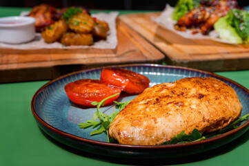 Close view meal with skinless chicken breast, arugula and fried tomatoes