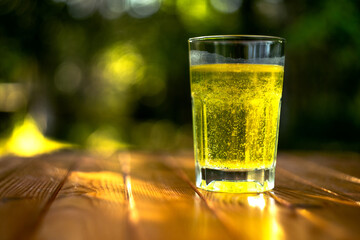 Glass with orange medicine on a summer background