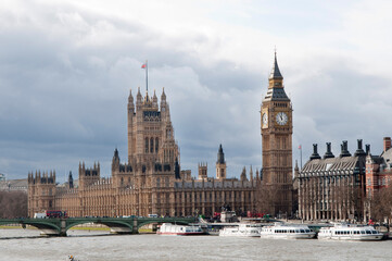 Fototapeta na wymiar Londres: Casas del parlamento y big ben en un día con sol y nubes
