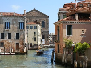 Canal in Venice with a boat and city views. Photo by mobile phone
