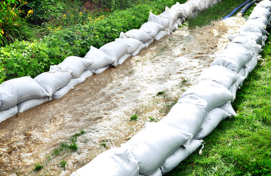 Sand Bags Surround Flood Waters On The Grass.