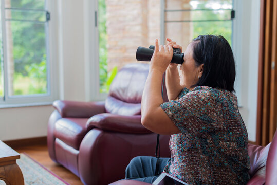 Senior Asian Woman Using Binocular For Bird Watching.