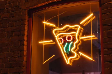 Fotobehang Neon sign slice of pizza on the window of the pizzeria at night glows advertisement © evgris
