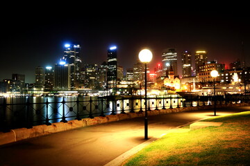 Fototapeta premium Night View of Sydney Promenade. Skyscrapers are seen across the water of Sydney Harbour.