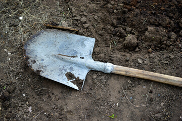 Garden iron shovel on the background of excavated soil