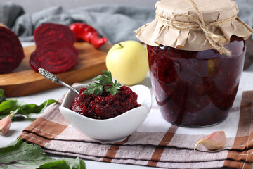 Homemade caviar from beets and apples in bowl and glass jar on light background, Horizontal format