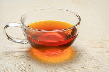 rooibos red tea  -  a glass cup of a hot drink, tea made from the South African red bush, naturally caffeine free