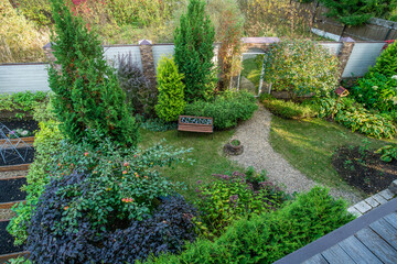 Aerial view from russian dacha on garden with apple tree, footpath, thujas, hostas and mirror