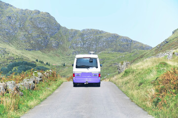 Purple campervan in remote mountain road trip