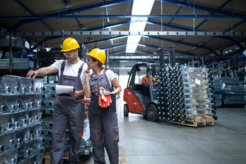 Factory workers checking quality of products in industrial warehouse. In background forklift machine. © littlewolf1989