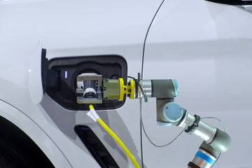 Close-up automation robotic working with handgrip of rechargeable electricity machine for recharge battery to white smart Electrical Vehicle or EV car