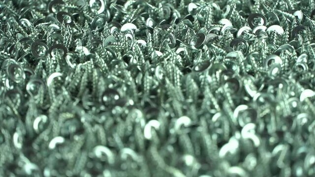 Video with selective focus. Metallic texture background. Background of the bolts. Screws and cogs. Tools for fixing and repairing. Stainless steel bolts. Galvanized metal fasteners. Close up. 4k