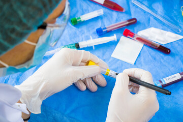 Doctor in laboratory with uniform write text on the blood tube sample