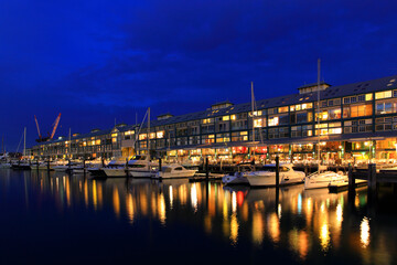 Fototapeta na wymiar Walsh bay residential property buildings with yachts at night. Upscale, luxury waterfront Sydney property