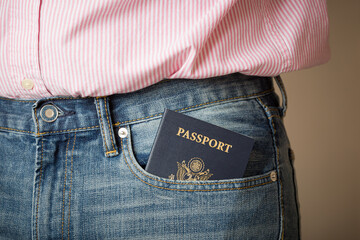 American passport in jeans pocket close-up. A young man in a white shirt and jeans prepares for a business trip. Traveling around the world.