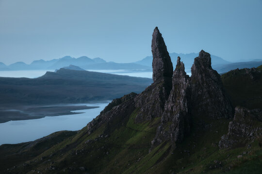Stunning view of the high sharp cliffs towering over the lakes and the sea before dawn. The Old Man of Storr, The Isle of Skye, Scotland, UK.